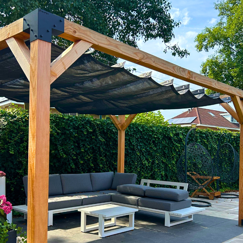 Houten pergola van Douglas hout (12x12 cm) met zwart harmonicadoek. Luxe terrasoverkapping met stevige metalen koppelstukken, ideaal voor een sfeervolle loungeplek in de tuin.