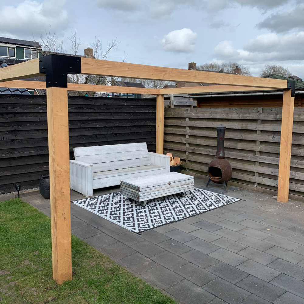 Houten pergola met zwarte metalen koppelstukken in een moderne tuin. Robuuste Douglas constructie als basis voor een overkapping of schaduwdoek.